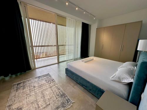 a bedroom with a bed and a large window at Queens Luxury Vila 111B in Vlorë