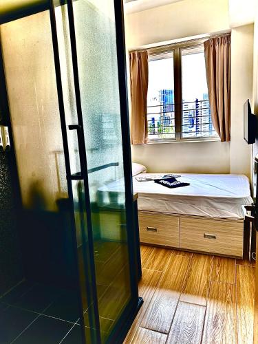 a small bedroom with a bed and a window at 木居 Woody House in Hong Kong