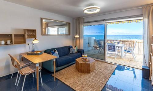 a living room with a blue couch and a table at Oceanfront Oasis By Dream Homes Tenerife in Acantilado de los Gigantes