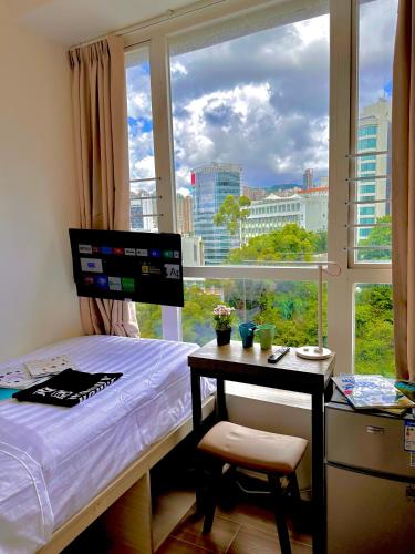 a bedroom with a bed and a desk and a window at 木居 Woody House in Hong Kong