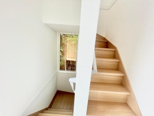 a staircase in a house with a window at GENYA Furano in Nakafurano