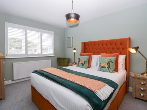 a bedroom with a large bed with orange and green pillows at Bishop Fell in Newby Bridge