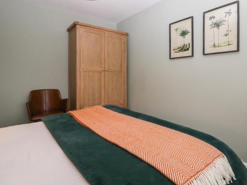 a bedroom with a bed and a wooden cabinet at Bishop Fell in Newby Bridge