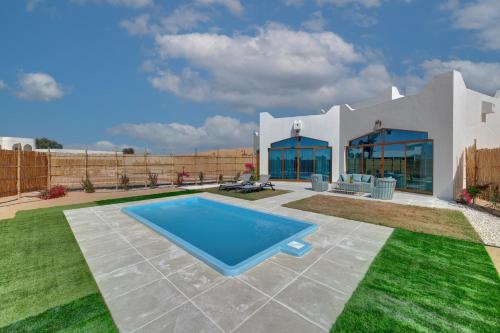 a house with a swimming pool in the yard at Western Hotel Liwa in Liwa