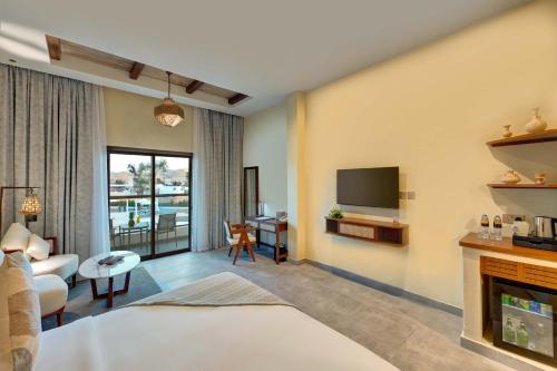 a hotel room with a bed and a tv at Western Hotel Liwa in Liwa