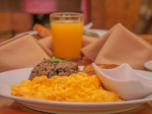 a plate of food on a table with a glass of orange juice at Hotel de Montaña Suria in San Gerardo de Dota