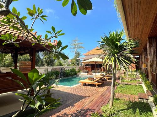 a resort with a pool and a patio with benches at Puri Melati in Uluwatu