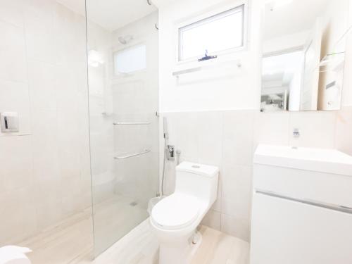 a white bathroom with a toilet and a shower at Ventanas del Mar by Playa Caracol 3 Habitaciones in Punta Chame