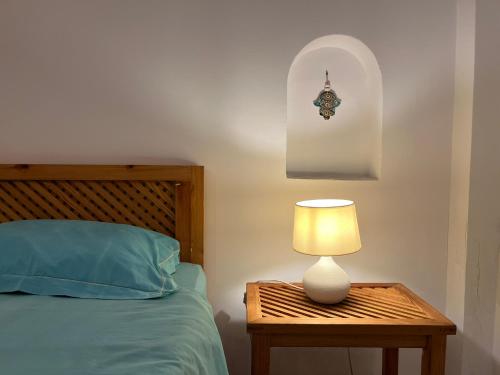 a bed with a table with a lamp on it at Villa Carpe Diem in Sangho