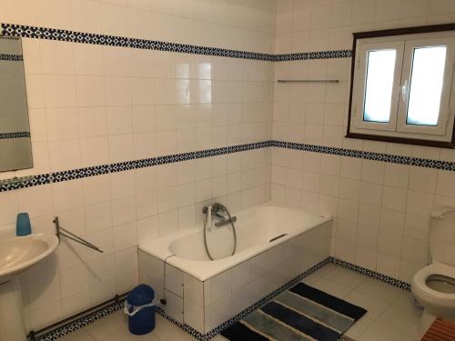 a bathroom with a tub and a sink and a toilet at Villa Carpe Diem in Sangho