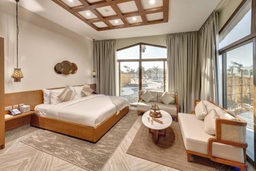 a bedroom with a king bed and a living room at Western Hotel Liwa in Liwa