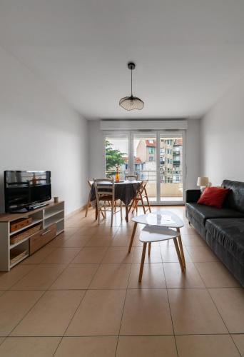 un salon avec un canapé et une table dans l'établissement L'Eugenie - Appartement design & confort en centre-ville, à Vichy