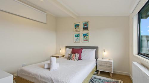 a white bedroom with a bed and a window at Alpine Heights 9 in Mount Hotham