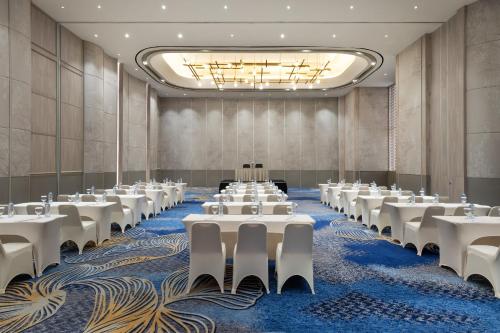 a conference room with white tables and chairs at Hotel Santika Premiere Lampung in Bandar Lampung