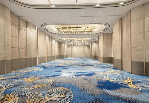 a hallway with a blue and gold carpet at Hotel Santika Premiere Lampung in Bandar Lampung