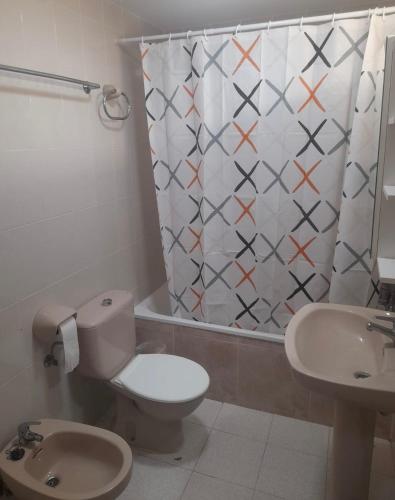 a bathroom with a toilet and a shower curtain at La caleta in Oropesa del Mar
