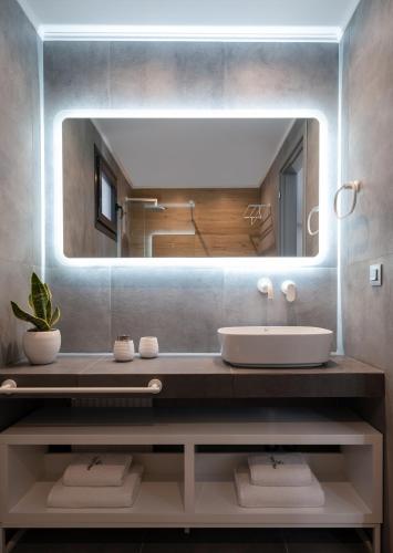 a bathroom with a sink and a large mirror at MySarti Villas in Sarti