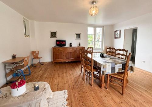 ein Esszimmer mit einem Tisch und Stühlen in einem Raum in der Unterkunft Maison à la campagne pour 7 pers, wifi et parking in Aube-sur-Rîle