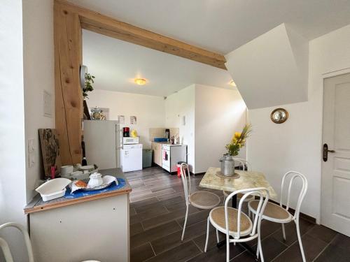 eine Küche und ein Esszimmer mit Tisch und Stühlen in der Unterkunft Maison à la campagne pour 7 pers, wifi et parking in Aube-sur-Rîle