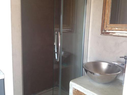 une salle de bain avec un lavabo et une douche en verre dans l'établissement Appartement à Giens vue Porquerolles, à Hyères