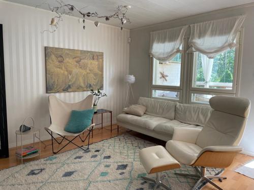 a living room with a couch and two chairs at Peaceful Residence Helsinki Laajasalo in Helsinki
