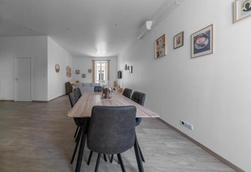 une salle à manger avec une table et des chaises en bois dans l'établissement Le Ravy - Appartement design, 2 chambres, centre ville, à Vichy