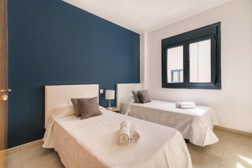 una habitación con dos camas y una ventana en Blue & White House, en Vecindario