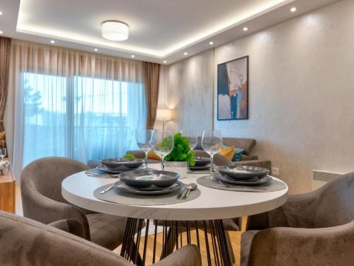 a dining room with a table with glasses and chairs at Vila Pino Silvestre in Zlatibor