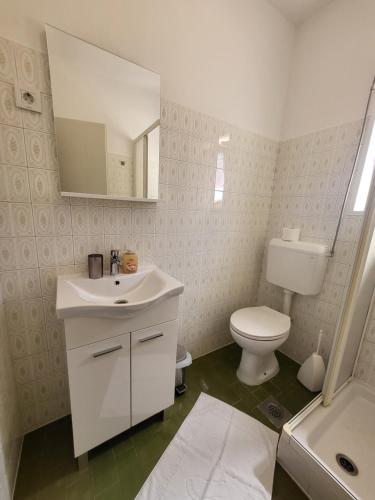 a bathroom with a sink and a toilet and a mirror at Margaret 150 METERS TO THE BEACH in Banjole