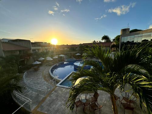a view of a resort with a pool and palm trees at Solar Agua Flats Elegance Flat in Pipa