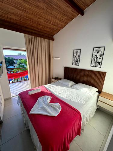 ein Schlafzimmer mit einem großen Bett mit einer roten Decke in der Unterkunft Solar Agua Flats Elegance Flat in Pipa