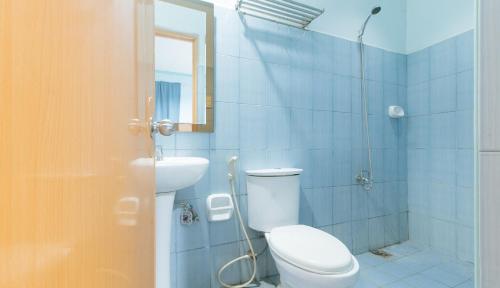 a bathroom with a toilet and a sink and a shower at RedDoorz @ Raj Inn Guimaras in Oracon