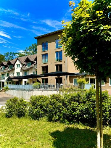 a large apartment building with a tree in front of it at 2tHEIMAT - Hotel & Restaurant in Morbach