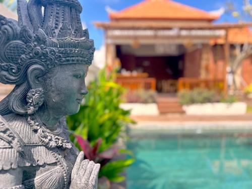 a statue of a woman standing next to a pool at Puri Melati in Uluwatu