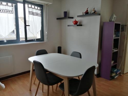une salle à manger avec une table et des chaises blanches dans l'établissement AppartMalo, à Saint-Malo