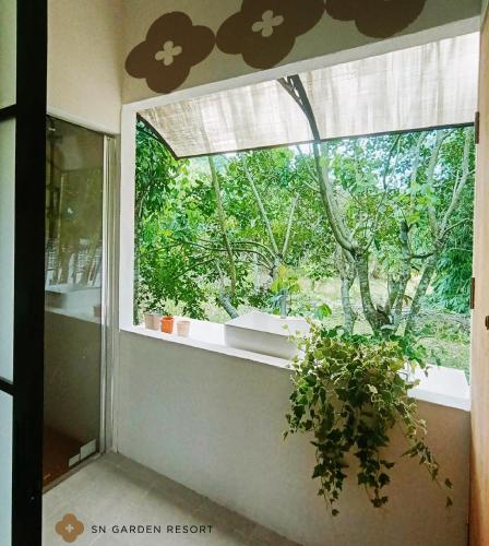 a window in a room with a potted plant at SN Garden in Ban Bo Hin