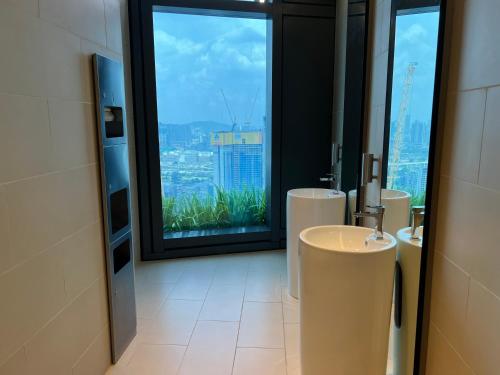 a bathroom with three sinks and a large window at Eaton Residence Suites KLCC in Kuala Lumpur