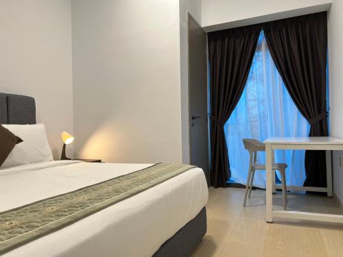 a bedroom with a bed and a table and a window at Eaton Residence Suites KLCC in Kuala Lumpur