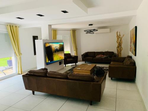 un salon avec deux canapés et une télévision à écran plat dans l'établissement Chambre Ramonville-Saint-Agne, à Ramonville-Saint-Agne