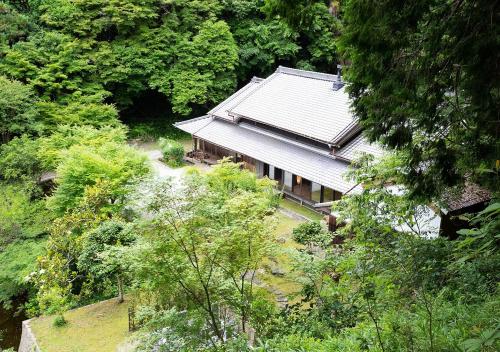 an overhead view of a house in a forest at 古民家やまおか in Iwasaki