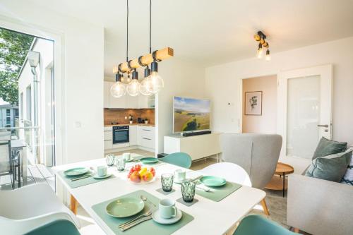 a dining room with a white table and chairs at Apartment "Pine Hill Green" in Zirchow