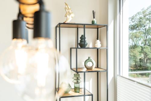 a shelf with vases on it next to a window at Apartment "Pine Hill Green" in Zirchow