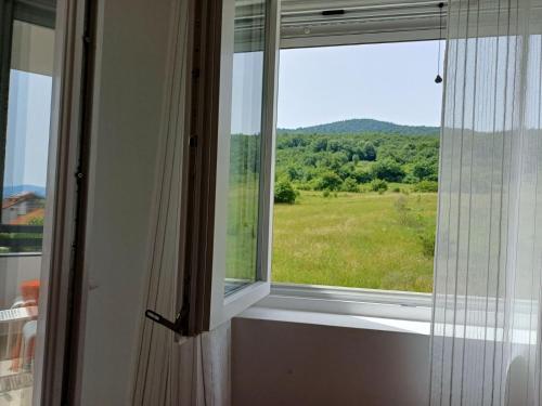 a window with a view of a green field at Apartman s parkingom, blizu Akva parka, Natura Lux - Green Hill, Sokobanja in Soko Banja