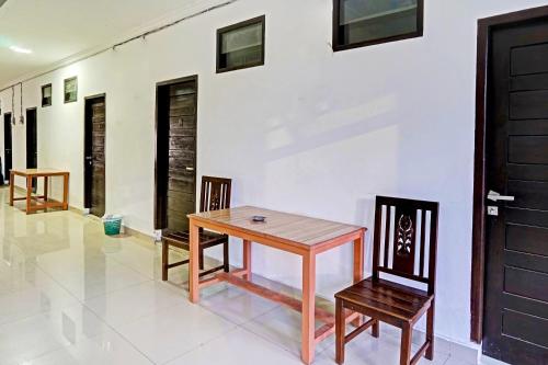 a table and two chairs in a room at Hotel O Kambang Iwak Area Near Kambang Iwak Park Formerly Kerangga in Palembang