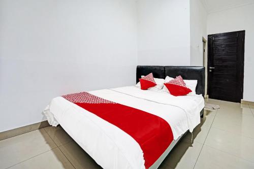 a red and white bed in a white room at Hotel O Kambang Iwak Area Near Kambang Iwak Park Formerly Kerangga in Palembang