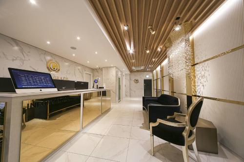 a lobby with a desk with a laptop on it at Grazie Hotel Tanhyeon in Goyang