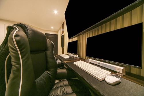 a desk with a computer monitor and a keyboard and mouse at Grazie Hotel Tanhyeon in Goyang