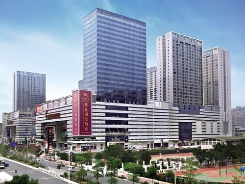 a large building in a city with tall buildings at Pearl River International Hotel - Canmetro line 11 YiJing Lu station in Guangzhou