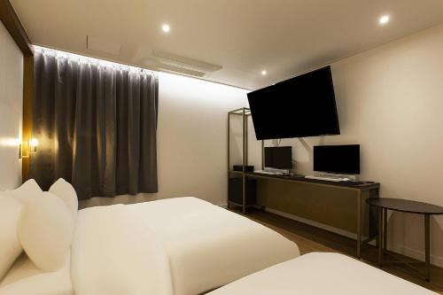 a hotel room with a bed and a television at Grazie Hotel Tanhyeon in Goyang