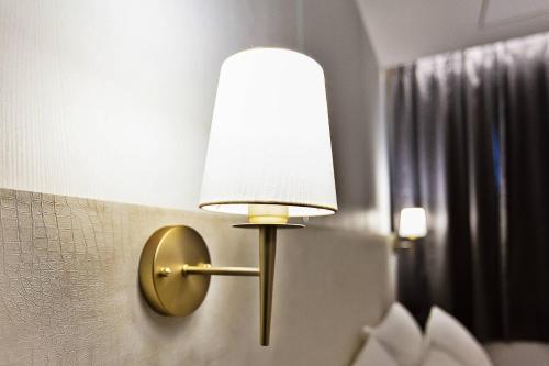 a lamp attached to a wall with a light on it at Grazie Hotel Tanhyeon in Goyang